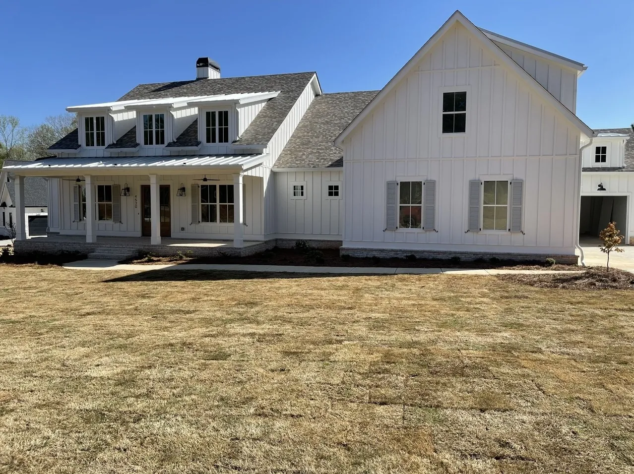 Gray composite louvered shutters, front of a white board-and-batten farmhouse – American Shutter Company, serving Woodstock, GA 30188